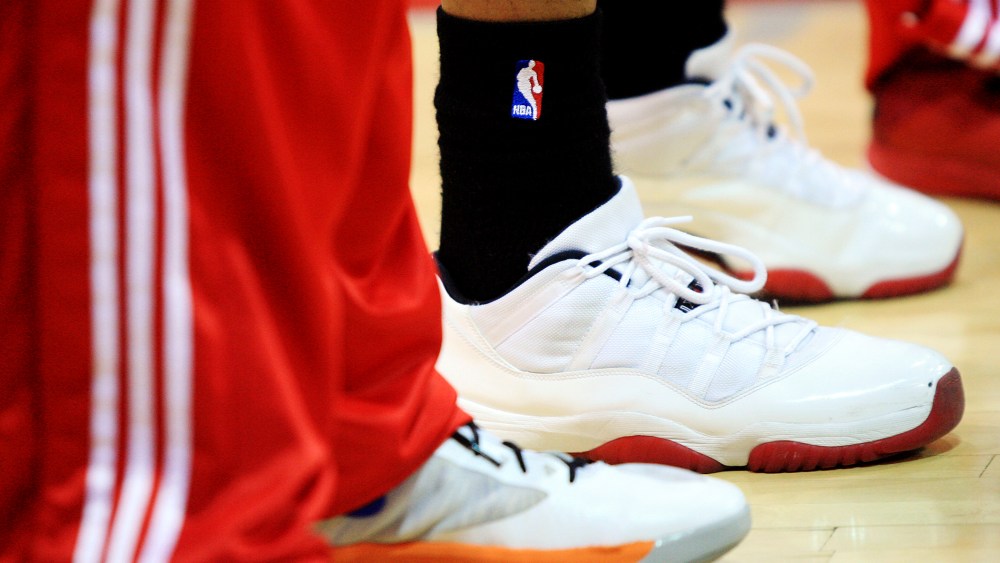 NBA logo is displayed on a pair of socks during a game.