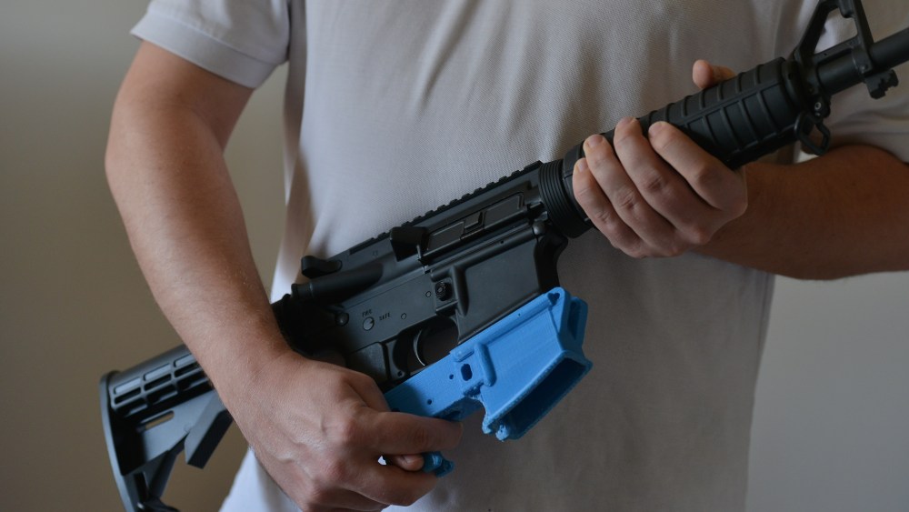 A man holds an AR-15 assault rifle with a lower receiver made of ABS (Acrylonitrile Butadiene Styrene) plastic constructed by a 3D printer, Feb. 12, 2012.