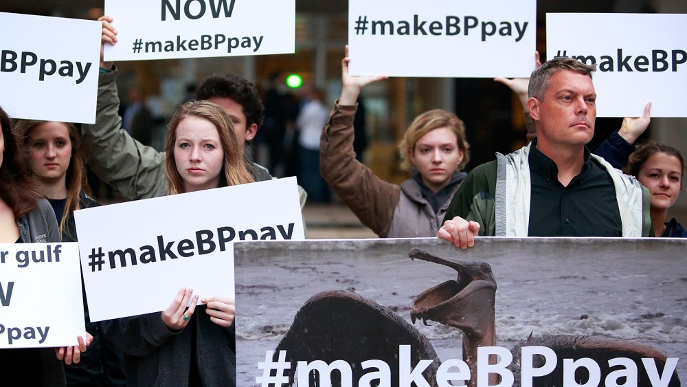 Activists holds signs during a protest in front of the Hale Boggs Federal Building, Feb. 25, 2013.