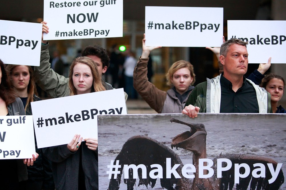 Activists holds signs during a protest in front of the Hale Boggs Federal Building, Feb. 25, 2013.