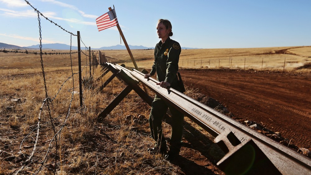 A U.S. Border Patrol agent looks into Mexico from the U.S.-Mexico border on February 26, 2013 near Sonoita, Arizona.