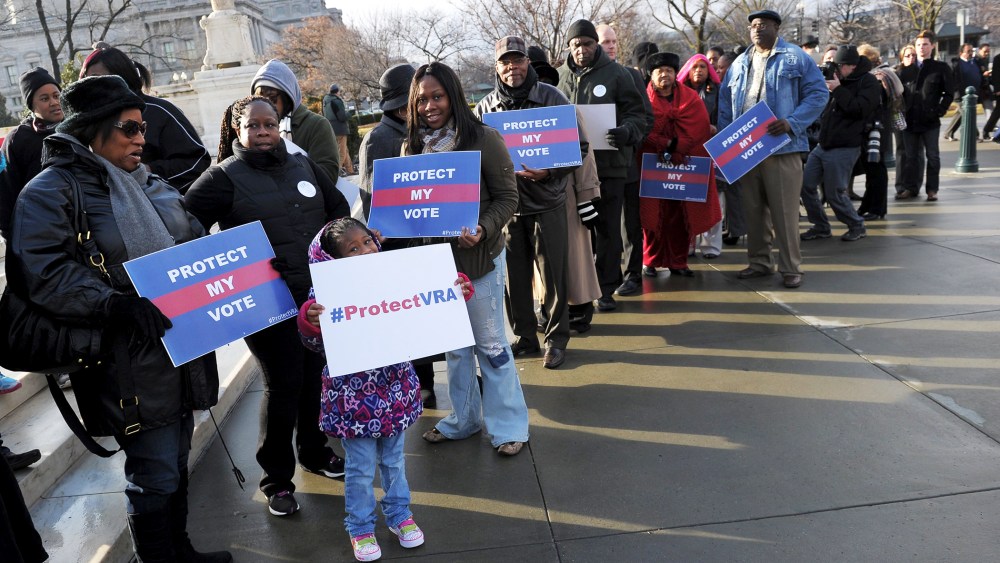 Activists hold pro-voting rights placards outside of the US Supreme Court, Feb. 27, 2013.