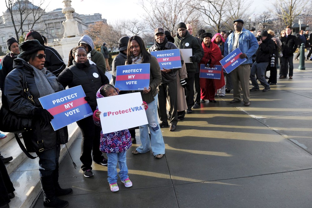 Activists hold pro-voting rights placards outside of the US Supreme Court, Feb. 27, 2013.