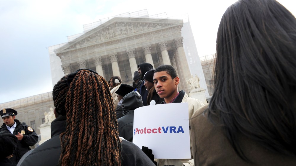 An activist holds a pro-voting rights placards outside of the US Supreme Court in Washington, DC, Feb. 27, 2013.