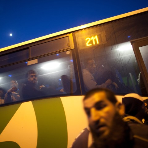 Palestinians board a bus as a new line is made available by Israel to take Palestinian workers from the Israeli army crossing of Eyal, near the West Bank town of Qalqilya, into the Israeli cities, on March 4, 2013. (Photo by Uriel Sinai/Getty)