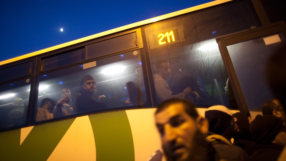Palestinians board a bus as a new line is made available by Israel to take Palestinian workers from the Israeli army crossing of Eyal, near the West Bank town of Qalqilya, into the Israeli cities, on March 4, 2013. (Photo by Uriel Sinai/Getty)