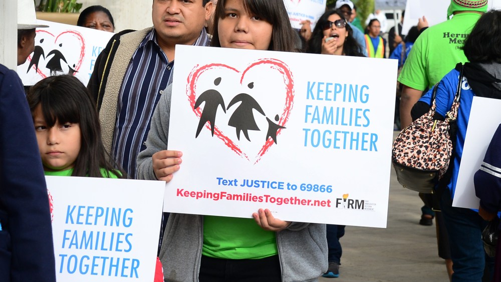 Immigrant families and supporters of their cause hold banners and shout slogans while marching in front of Senator Dianne Feinstein's office on March 4, 2013 in Los Angeles, California, at the launch of a caravan tour called "Our Golden Promise -...