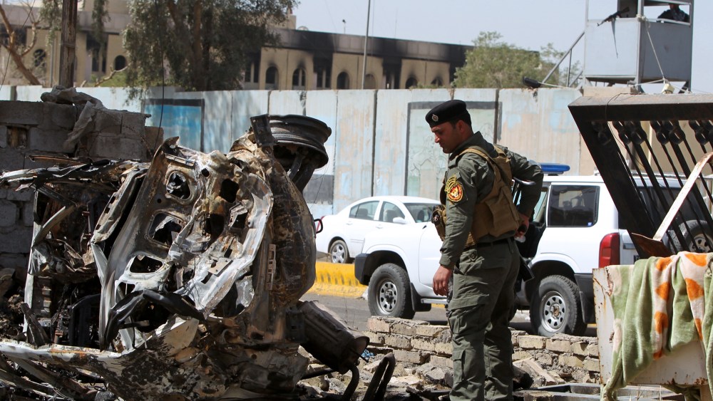 A member of Iraq's internal security forces inspects the damage outside the Iraqi justice ministry in Baghdad on March 15, 2013, a day after militants staged an apparently unsuccessful assault. A coordinated string of bombings and a brazen assault on...