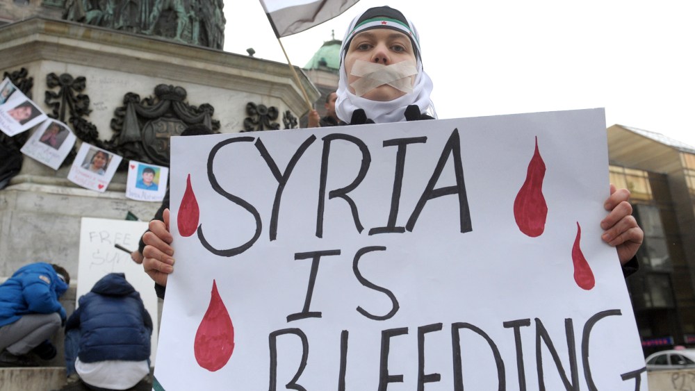 A Syrian living in Serbia displays a placard on March 16, 2013 during a protest against Syria's President Bashar al-Assad in the center of Belgrade.  (Photo by Alexa Sankovic/AFP/Getty Images)