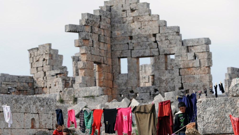 Syrian refugees hang out their clothes to dry in the ruins of the ancient Roman city of of Serjilla, in the northwestern province of Idlib, on March 19, 2013. The conflict has killed at least 70,000 people, and forced more than one million Syrians to...