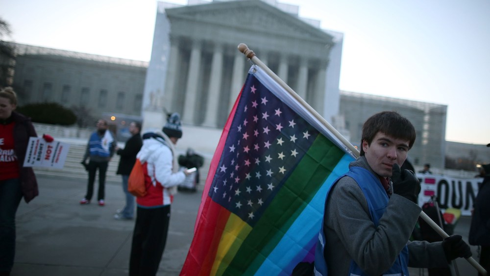 Justin Kenny of Akron Ohio holds a modified Stars and Stripes flag in front of the U.S. Supreme Court, on March 26, 2013 in Washington, D.C.