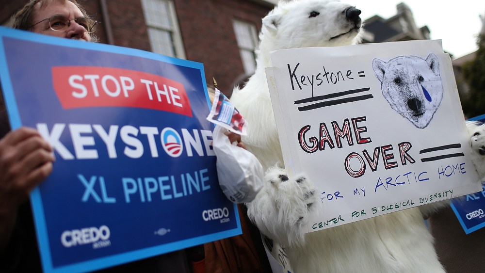 Demonstrators hold signs as they protest near the site of a fundraiser on April 3, 2013 in San Francisco, California.  Hundreds of protesters staged a demonstration against war and the Keystone XL pipeline outside of a fundraiser to be attended by U.S....