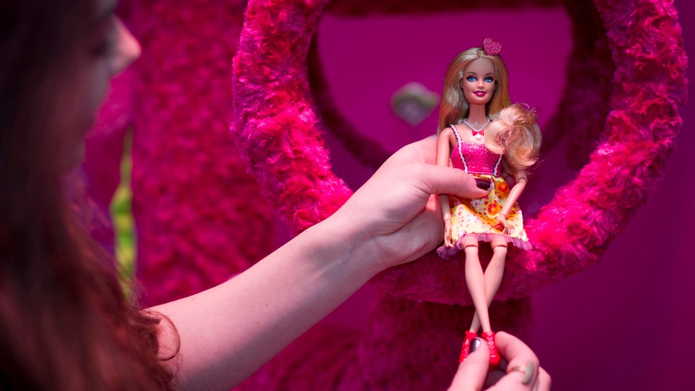 A woman holds a Barbie doll at 'Barbie: The Dreamhouse Experience' on April 12, 2013 in Berlin, Germany. (Timur Emek/Getty)