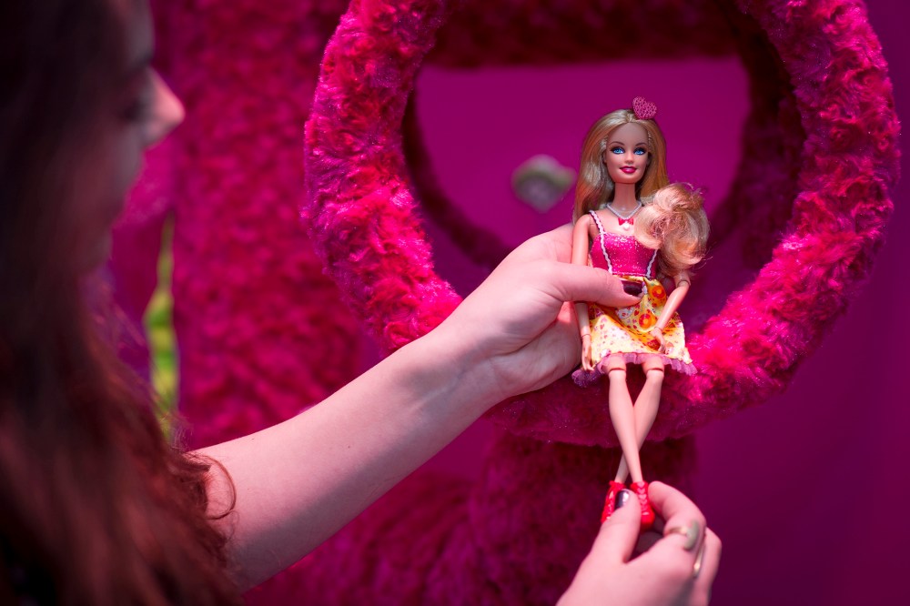 A woman holds a Barbie doll at 'Barbie: The Dreamhouse Experience' on April 12, 2013 in Berlin, Germany. (Timur Emek/Getty)