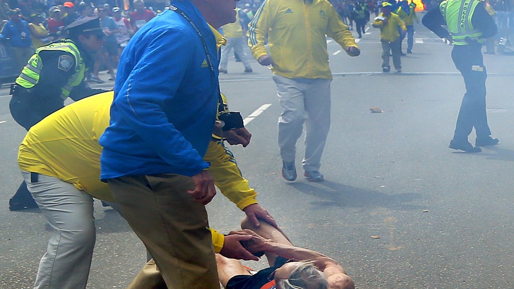 A second explosion goes off (rear) as a runner was blown to the ground by the first explosion near the finish line of the 117th Boston Marathon. (Photo by John Tlumacki/The Boston Globe via Getty Images)