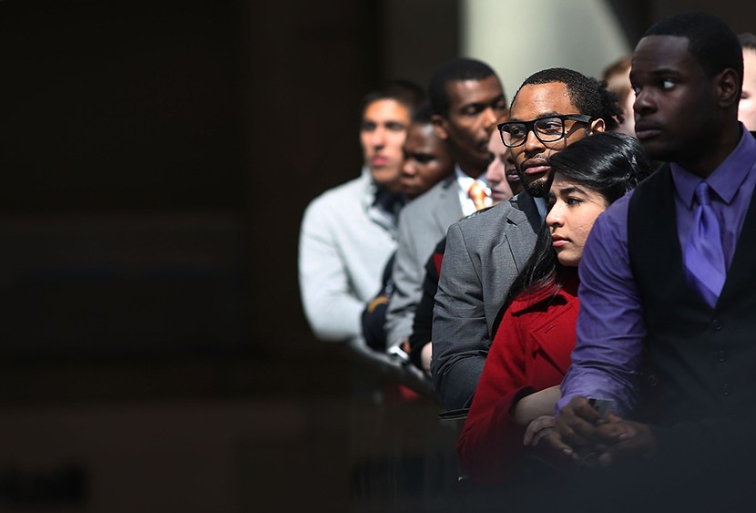 Job seekers wait in line to meet with employers at a job fair in NYC, April 26, 2013.