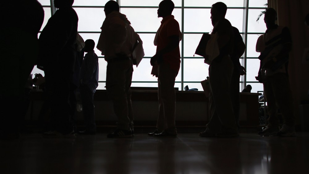 People looking for work stand in line to apply for a job during a job fair in Miami, Fla. (Photo by Joe Raedle/Getty)