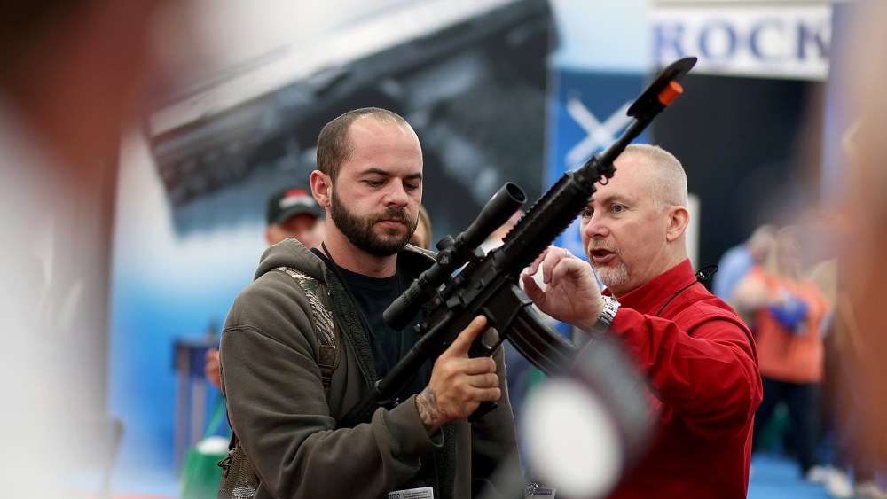 An attendee inspects a scope on an assault rifle during the 2013 NRA Annual Meeting and Exhibits in Houston, Texas, May 3, 2013.