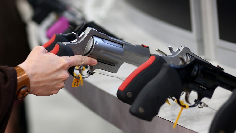 An attendee inspects a handgun during the 2013 NRA Annual Meeting and Exhibits at the George R. Brown Convention Center on May 3, 2013 in Houston, Texas. (Photo by Justin Sullivan/Getty Images)