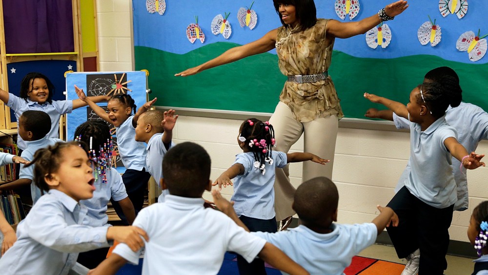 U.S. first lady Michelle Obama dances with pre-kindergarten students while she visits the Savoy School in D.C., May 24, 2013.