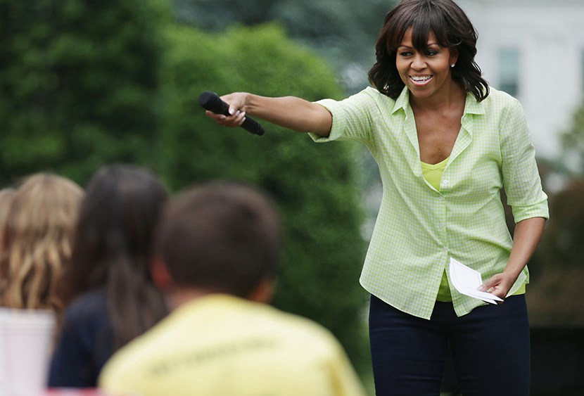 First lady Michelle Obama speaks to school children before they harvest the summer crop from the White House Kitchen Garden at the White House on May 28, 2013 in Washington, DC. (Photo by Chip Somodevilla/Getty Images)