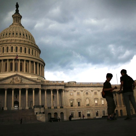 Two men stand on the plaza of the U.S. Capitol Building as storm clouds fill the sky, June 13, 2013 in Washington, DC.