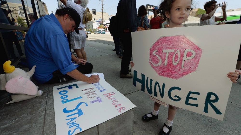 Gracie Shannon-Sanborn, 5, holds a sign as she joins her father Allen Sanborn (L) and members of Progressive Democrats of America and other activists as they hold a rally in front of Rep. Henry Waxman's office on June 17, 2013 in Los Angeles,...
