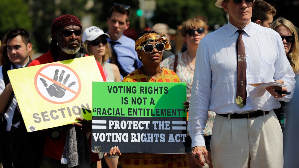 Supporters of the Voting Rights Act listen to speakers discussing today's rulings outside the U.S. Supreme Court building on June 25, 2013 in Washington, DC. (Photo by Win McNamee/Getty Images)