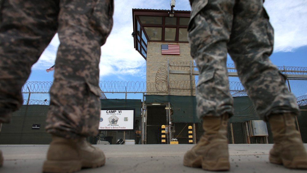 Military officers stand at the entrance to Camp VI and V at the U.S. military prison for 'enemy combatants' on June 25, 2013 in Guantanamo Bay, Cuba.