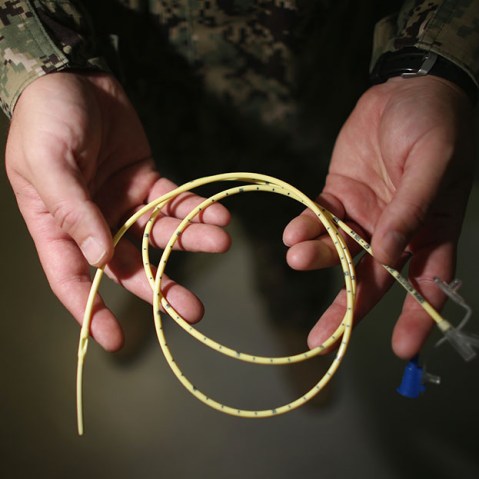 A military doctor holds a feeding tube used to feed detainees on hunger strike at the detainee hospital in Camp Delta which is part of the U.S. military prison for 'enemy combatants' on June 26, 2013, in Guantanamo Bay, Cuba. (Photo by Joe Raedle/Getty...