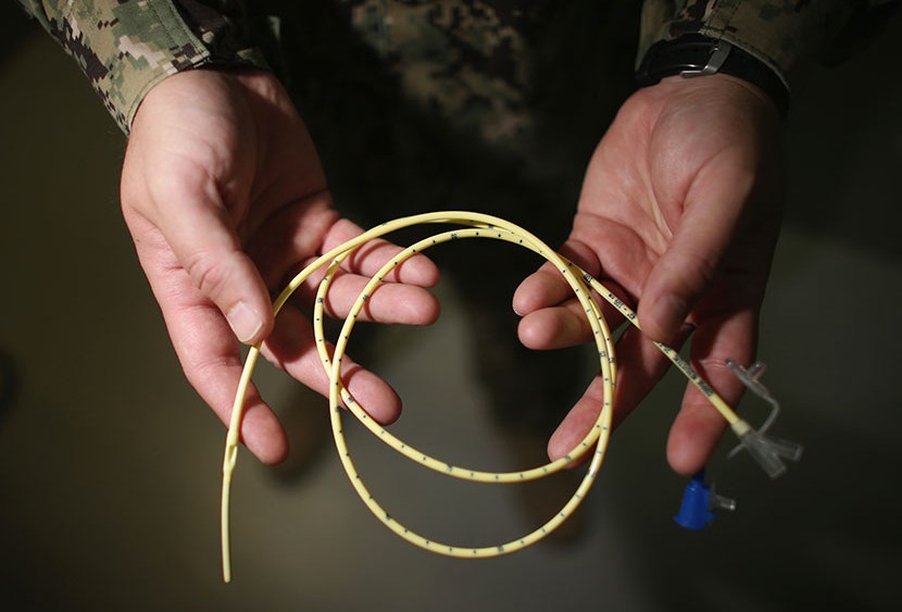 A military doctor holds a feeding tube used to feed detainees on hunger strike at the detainee hospital in Camp Delta which is part of the U.S. military prison for 'enemy combatants' on June 26, 2013, in Guantanamo Bay, Cuba. (Photo by Joe Raedle/Getty...