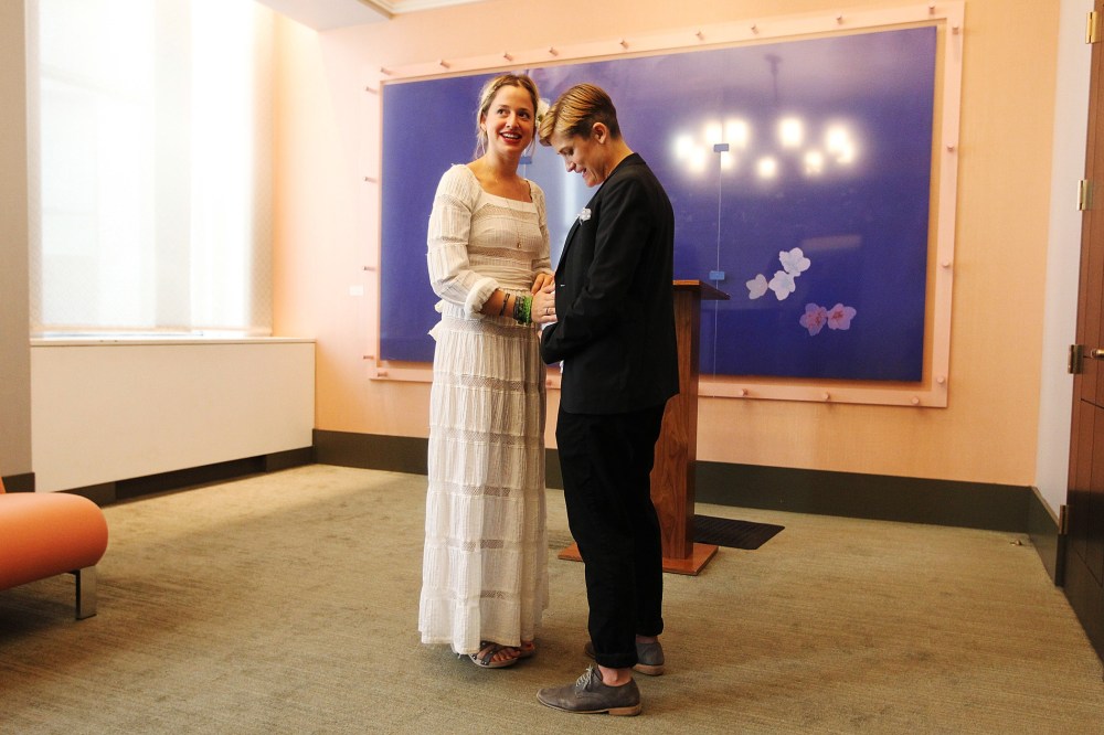 Stefanie Berks (L) touches Daisy Boyd's pregnant belly before their marriage ceremony at the Manhattan Marriage Bureau two days after the U.S. Supreme Court ruling on DOMA on June 28, 2013 in New York City.