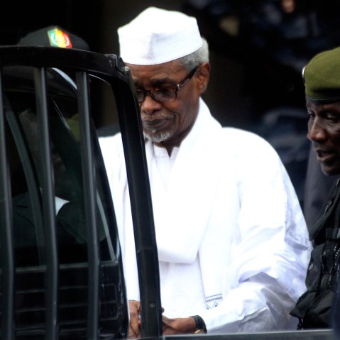 Former Chadian dictator Hissene Habre, charged with genocide, war crimes, torture and crimes against humanity, is escorted by military officers after being heard by judge on July 2, 2013 in Dakar. (Photo by STRINGER/AFP/Getty)