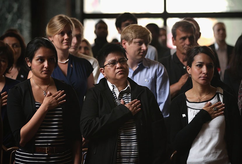 New U.S. citizens recite the Pledge of Allegiance during a naturalization ceremony at the Chicago Cultural Center on July 3, 2013. (Photo by Scott Olson/Getty)