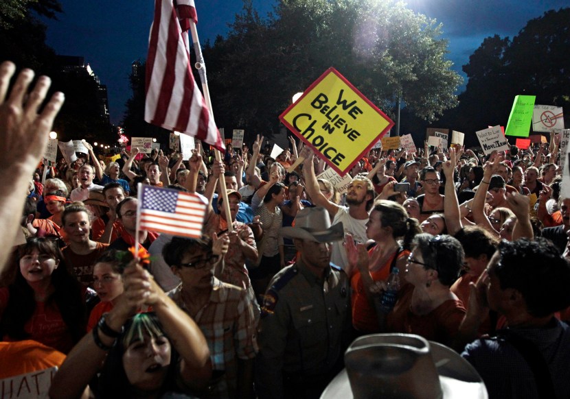 Pro-life supporters and pro-choice protesters rally at the Texas state capitol in favor and against the new controversial abortion legislation up for a vote in the state legislature on July 8, 2013 in Austin Texas. (Photo by Erich Schlegel/Getty Images)