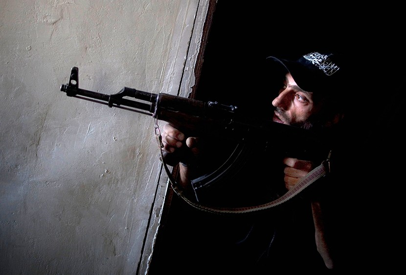 A rebel fighter points his gun towards pro-government forces' positions during clashes in the Salaheddine district of the northern Syrian city of Aleppo, on July 9, 2013.  (Photo by JM Lopez/AFP/Getty Images)