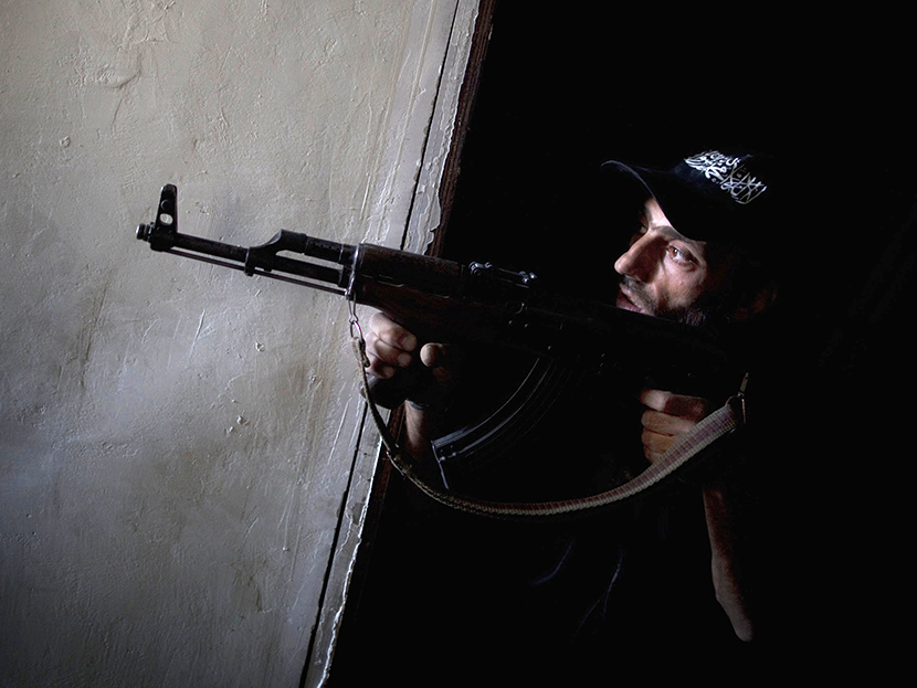 A rebel fighter points his gun towards pro-government forces' positions during clashes in the Salaheddine district of the northern Syrian city of Aleppo, on July 9, 2013. (Photo by JM Lopez/AFP/Getty Images)
