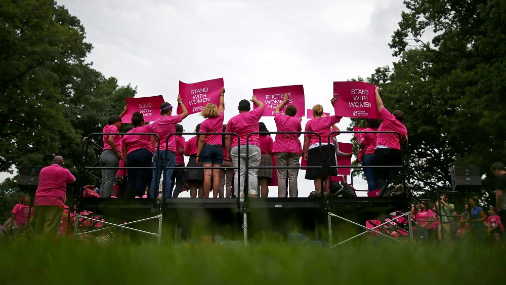 People hold up signs during a women's pro-choice rally on Capitol Hill, July 11, 2013 in Washington, DC.