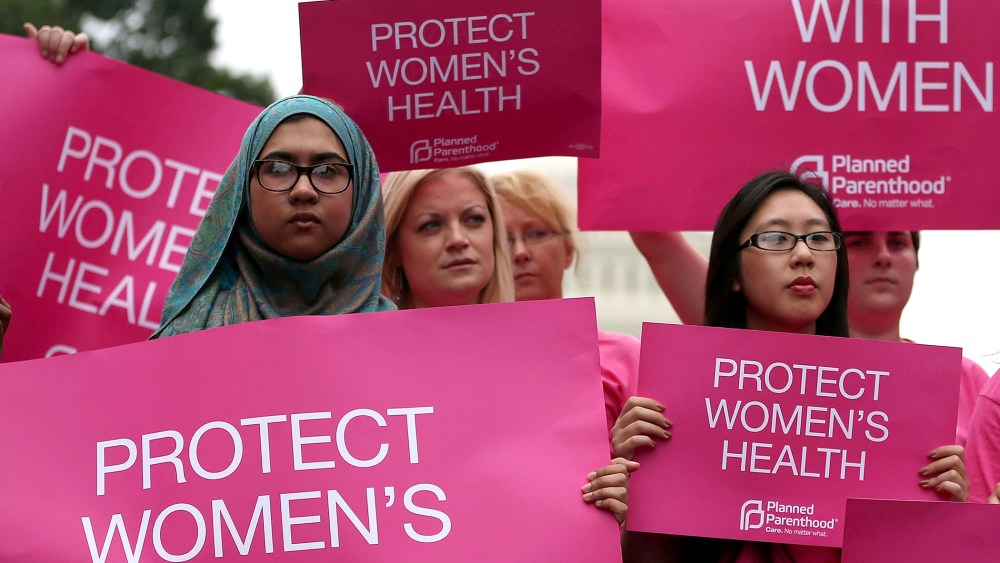 Women hold up signs during a women's pro-choice rally on Capitol Hill, July 11, 2013.