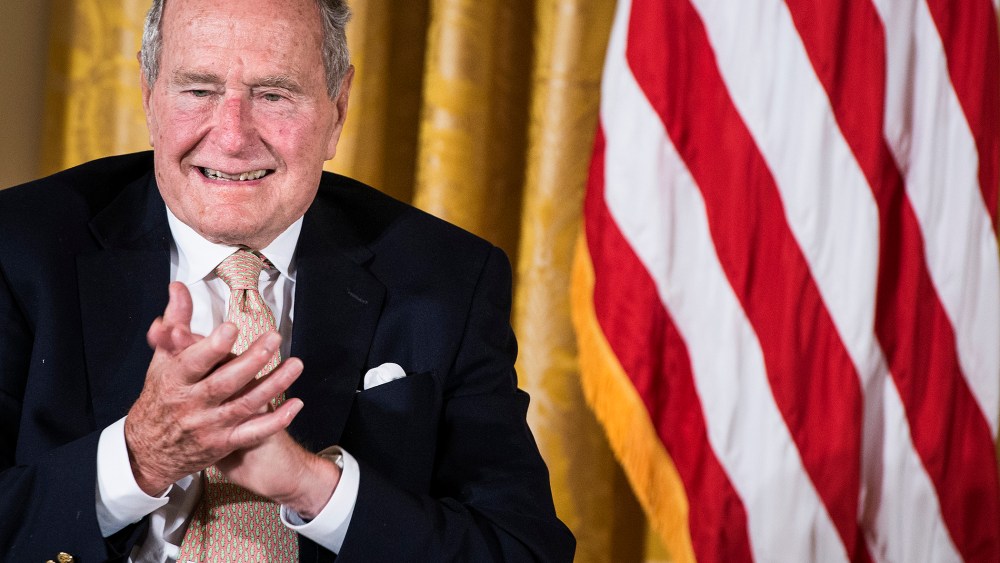 Former US President George H. W. Bush applauds during an event in the East Room of the White House July 15, 2013 in Washington, DC.
