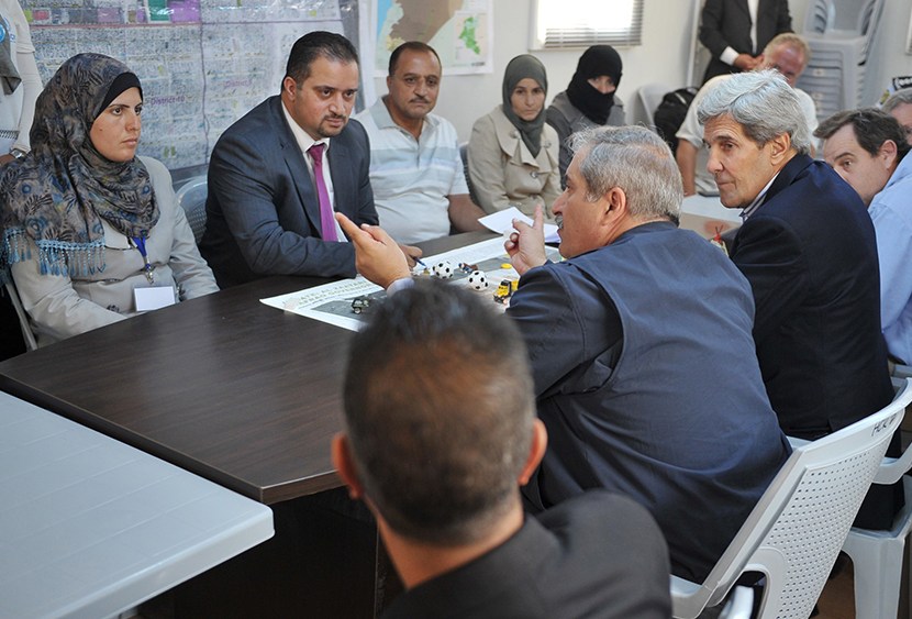 US Secretary of State John Kerry (C-R) and his Jordanian counterpart Nasser Judeh (C) meet with Syrian refugees at the Zaatari refugee camp near the Jordanian city of Mafraq on July 18, 2013.  (Photo by Mandel Ngan/AFP/Getty Images/Pool)
