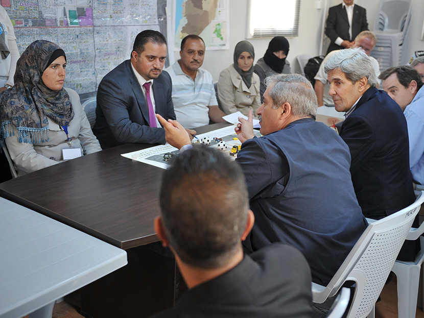 US Secretary of State John Kerry (C-R) and his Jordanian counterpart Nasser Judeh (C) meet with Syrian refugees at the Zaatari refugee camp near the Jordanian city of Mafraq on July 18, 2013. (Photo by Mandel Ngan/AFP/Getty Images/Pool)