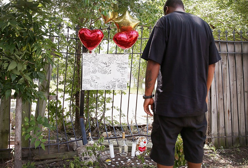 Anthony (no last name available) looks over a memorial for his friend Eugene Clark, 25, who was shot and killed Saturday on July 22, 2013 in Chicago, Illinois.  (Photo by Scott Olson/Getty Images)