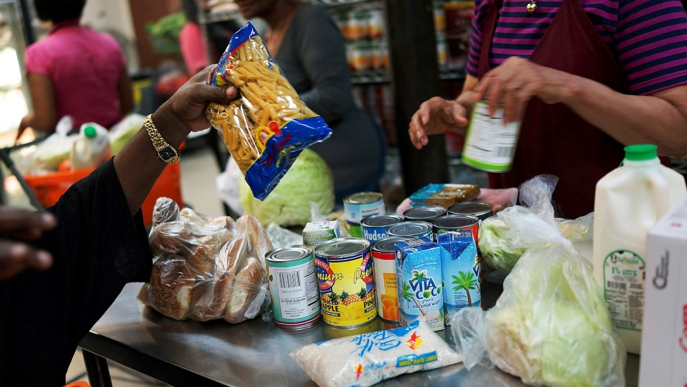 A client of the West Side Campaign Against Hunger food pantry fills up a box with food on July 24, 2013 in New York City. (Spencer Platt/Getty)