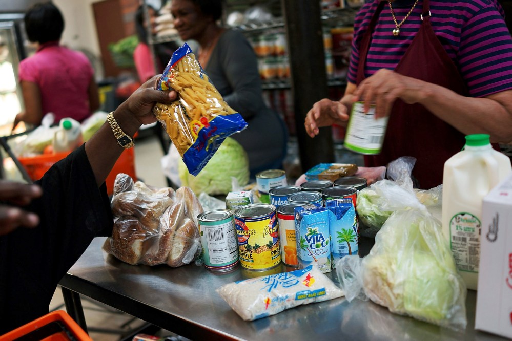 A client of the West Side Campaign Against Hunger food pantry fills up a box with food on July 24, 2013 in New York City. (Spencer Platt/Getty)
