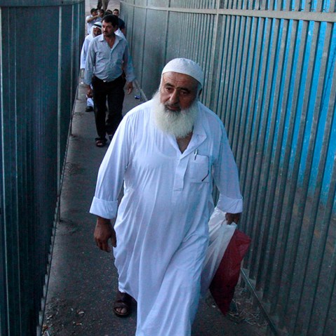 Palestinian Muslim worshipers walk through Israel's controversial separation barrier on the outskirts of the West Bank town of Bethlehem as they undergo security checks by Israeli security forces before heading to Jerusalem to attend  Friday prayers at...