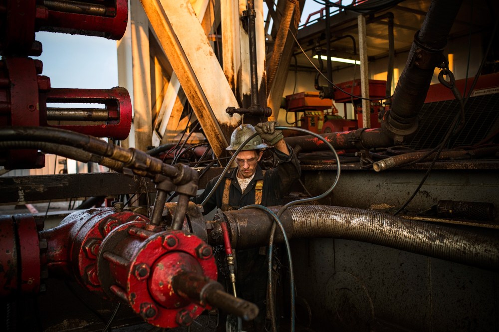 Ray Gerish, a floor hand for Raven Drilling, works on an oil rig drilling into the Bakken shale formation on July 28, 2013 outside Watford City, North Dakota. (Photo by Andrew Burton/Getty)