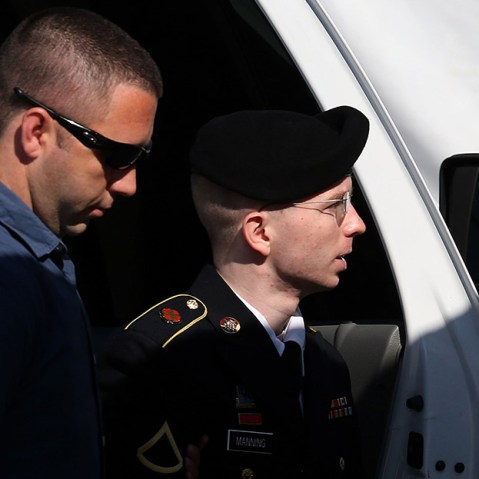 U.S. Army Private First Class Bradley Manning (R) is escorted by military police as arrives to hear the verdict in his military trial July 30, 2013, at Fort George G. Meade, Maryland.  (Photo by Mark Wilson/Getty Images)
