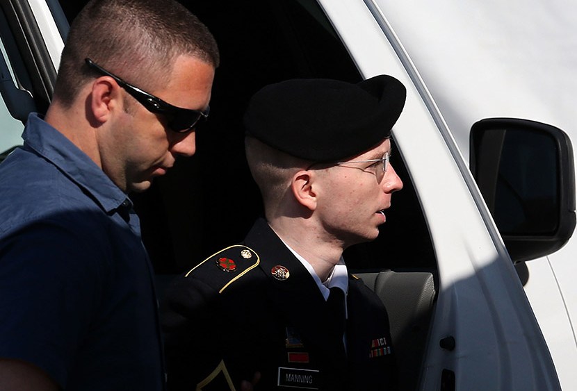 U.S. Army Private First Class Bradley Manning (R) is escorted by military police as arrives to hear the verdict in his military trial July 30, 2013, at Fort George G. Meade, Maryland.  (Photo by Mark Wilson/Getty Images)