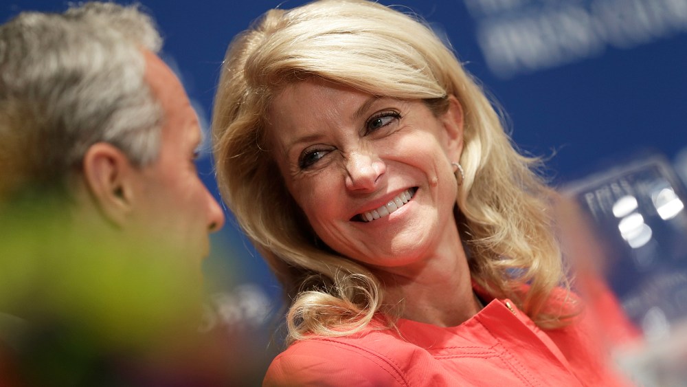 Texas State Sen. Wendy Davis talks with guests at the head table before speaking at the National Press Club August 5, 2013 in Washington, DC.